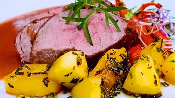 Saftiges Fleischstück mit gebratenen Kartoffeln und Gemüse.