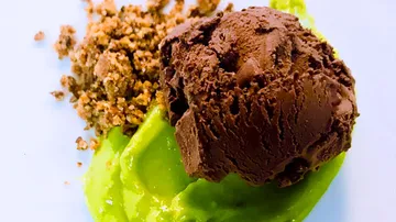 Grünes Eis mit Schokoladeneis und knusprigen Bröseln serviert.