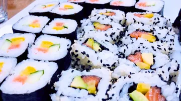 Sushi rolls are laid out on a white plate, appetizingly served.