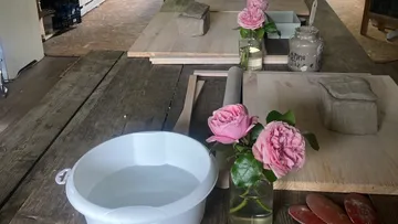 Pottery workshop with water, clay and fresh roses in glasses.