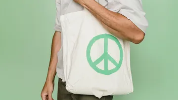 A dead bag with a peace sign is being held.