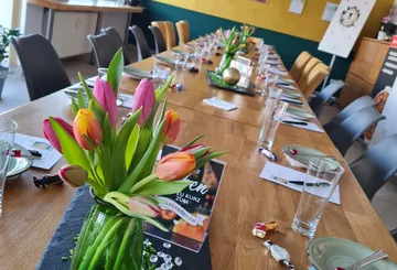 Ein Tisch mit Tulpen, gedeckt für ein Essen.