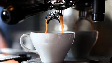 Kaffeetasse füllt sich mit frisch gebrühtem Espresso.
