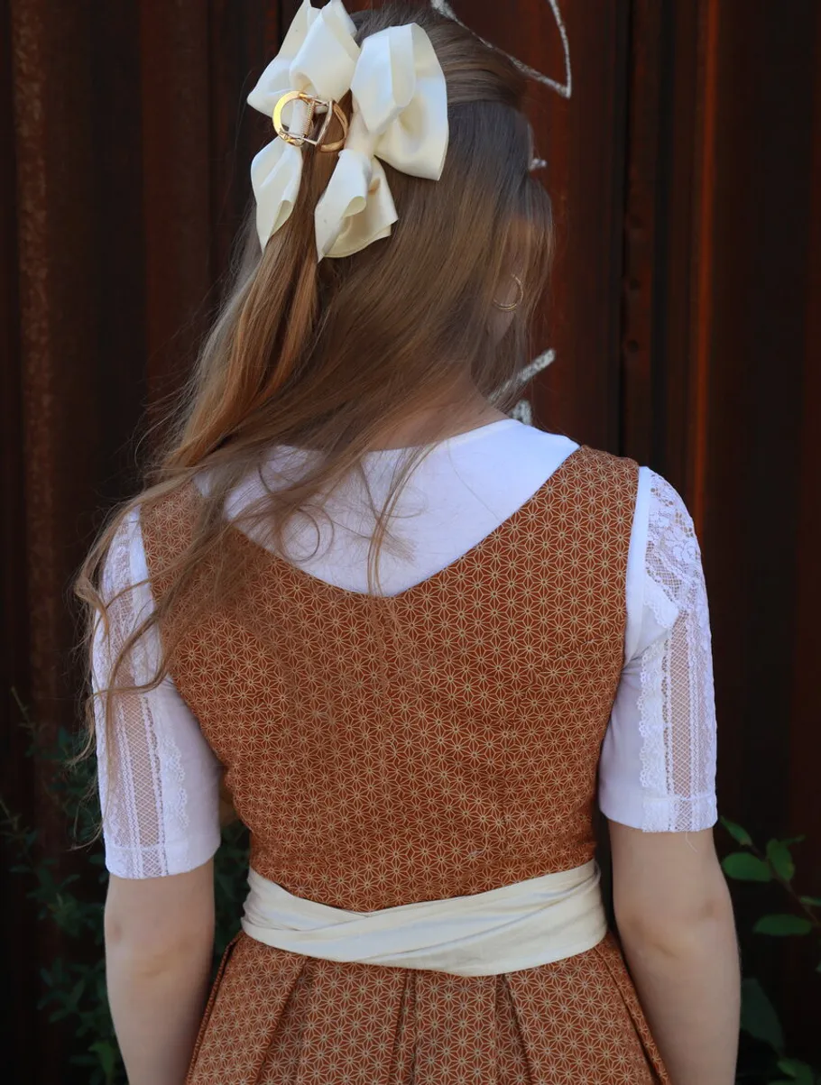 A person with a bow looks at a rustic wall.