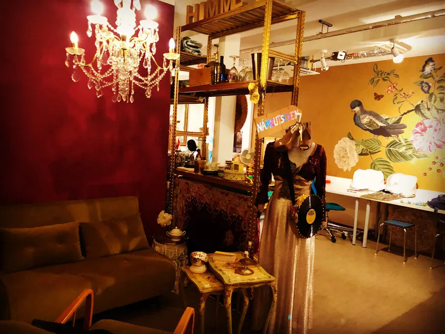 Cozy room with chandelier, mannequin, and mural.