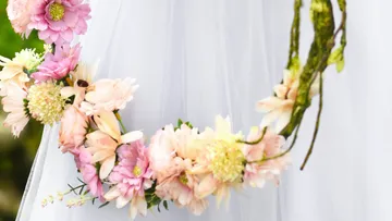 Blumenkranz hängt an einem weißen, transparenten Stoff.