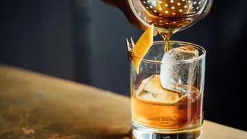 A cocktail glass is filled with a drink and ice.