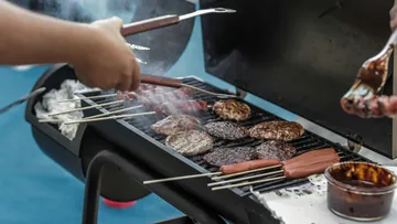Grill mit Fleisch und Würstchen; zubereitet im Freien.