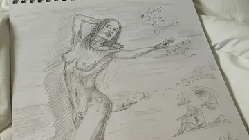 Nackte Frau posiert am Strand, umgeben von Urlaubern.