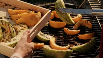 Kürbisscheiben werden auf einem Grill gegrillt.