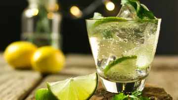 glass with a refreshing drink and lime slices.