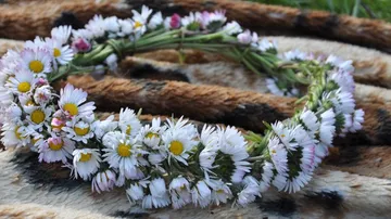 Blumenkranz liegt auf einem gefleckten Untergrund aus Stoff.