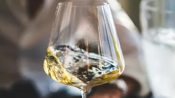 White wine swirls in an elegant wine glass.