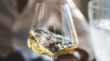 Weißwein schwenkt in einem eleganten Weinglas.