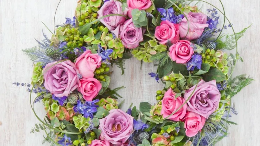 Flower wreath with pink roses, purple flowers, green leaves