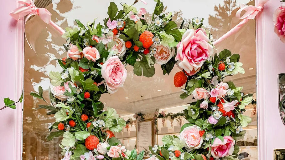 A wreath of flowers hangs decoratively on a window.