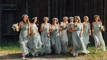 Ten women in green clothes laugh and walk together.