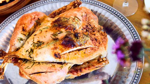 Roasted turkey is on a silver plate.