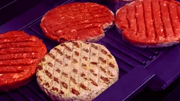 Burger-Patties grillen auf einem heißen Grillrost.