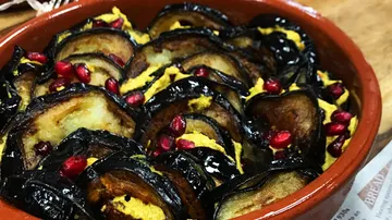 Fried eggplants with pomegranate seeds in a bowl.