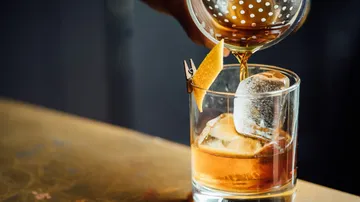 Cocktailglas wird mit einem Getränk gefüllt, eisgekühlt.