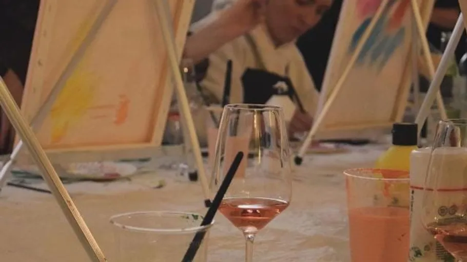 Wine glasses and paint easels on table.