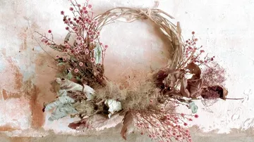 Wreaths of dried flowers hang decoratively on the wall.