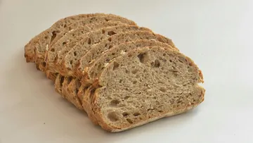 Scheiben von Brot liegen ordnungsgemäß auf einer weißen Oberfläche.