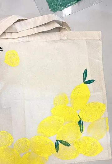 Stofftasche mit gelben Zitronenmotiven auf hellem Hintergrund.