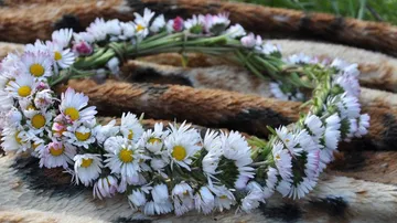 Blumenkranz liegt auf einem Muster aus Stoff.