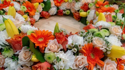 Bunte Blumenkranz liegt auf einem Holzuntergrund.