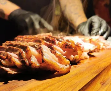 Cooked meat is cut into slices and served.