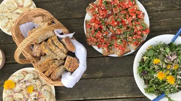 Korb mit Brot, belegt mit Tomaten, frischem Salat.