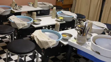Pottery workshop with workplaces and materials for making pottery.