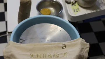 Round container with fabric and small objects on it