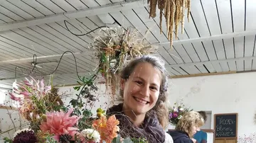 Woman smiling with colorful flowers in her hand. interior.