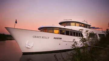 A boat is lying on the shore at sunset.