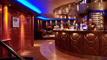 Elegant bar, bartender mixes drinks in a stylish setting.