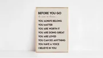 A frame with motivational messages stands in front of a wall.