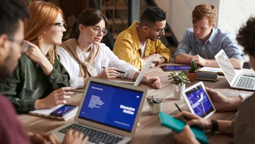 Group discusses together on computers and tablets.