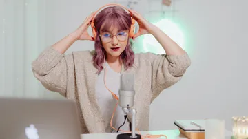 Woman with headphones listening to music in creative space.