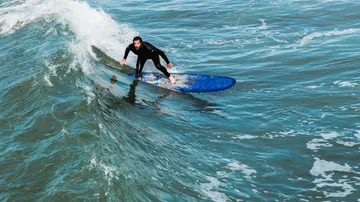 Surfer reitet auf einer Welle im Ozean.