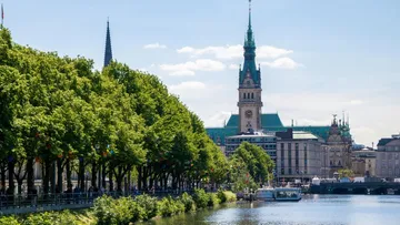 Grüner Uferbereich neben einem ruhigen Kanal in Hamburg.