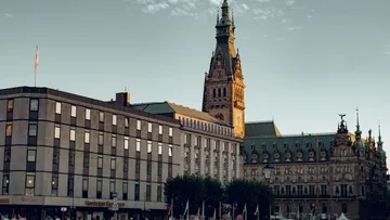 Historic town hall in Hamburg, surrounded by modern buildings.