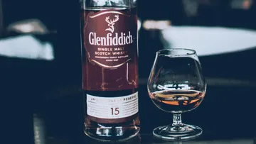 Flasche Glenfiddich Whisky steht neben einem Glas.