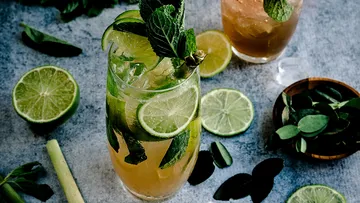 Erfrischendes Getränk mit Limetten und Minze, dekorativ präsentiert.
