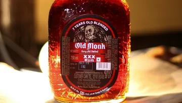 Alte Rumflasche steht im sanften Licht auf Oberfläche.
