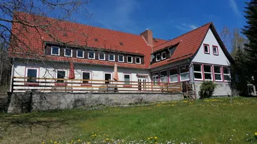 A large house is surrounded by green grass and trees.