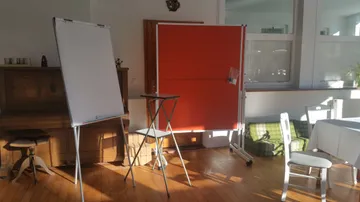 Presentation area with flip chart and chairs in the room.