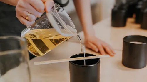 Oil is poured into a black container, work table.